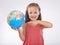 Lets give our children the world. A cute little girl holding a globe isolated on white.