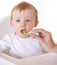 Lets give it a try. A cute baby receiving a spoonful of food from his mom.