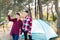 Lets go camping. Family camping. Reach destination place. Cheerful teenage girls talking on a video call, looking at the phone