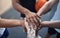 Lets go team. Closeup shot of a group of sporty young men joining their hands together in a huddle on a sports court.