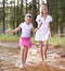 Lets go this way mom. A cute little girl running through a wilderness stream with her mother.