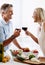 Lets toast to cooking. Cropped shot of an affectionate mature couple toasting with red wine while making dinner.