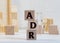 Letter block in word ADR Abbreviation of adverse drug reaction on wood background