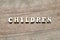 Letter block in word children on wood background