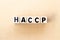 Letter block in word HACCP Hazard Analysis Critical Control Points on wood background