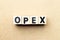 Letter block in word opex abbreviation of operating expense on wood background