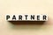 Letter block in word partner on wood background