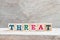 Letter block in word threat on wood background