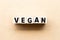 Letter block in word vegan on wood background