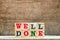 Letter block in word well done on wood background