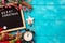 Letter board with words Merry Christmas, vintage clock and decorations on blue wooden table. Winter Christmas celebration concept