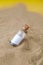 Letter in a bottle on the beach. Island lifestyle. Paper Message in a glass bottle with a cork on the sand. Note on