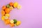 Letter C made with citrus fruits on lilac background as vitamin representation. Space for text