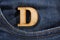 Letter D of the alphabet - blue jeans texture background. Top view