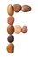 Letter F made of marine small pebbles. Alphabet made of stones Isolated on a white background