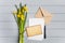 Letter, postcard, envelope and daffodils on grey background. Romantic holiday concept, top view, flat lay
