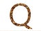 Letter Q of the alphabet made with brown wood chips