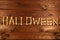 Lettering from the bones of the word Halloween on a beautiful brown wooden background. Design to celebrate Halloween day