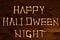 Lettering from the bones of the words Happy Halloween Night on a beautiful dark brown wooden background. Design to celebrate