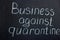 The lettering on the chalk board `Business against quarantine`