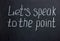 Lettering on a dark board "Let's speak to the point"