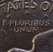 Lettering E Pluribus Unum, one out of many, on the reverse of the one dollar USA coin issued in 1978, isolated on the black