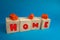 lettering home on wooden cubes and red miniature houses