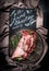 Lettering lamb shoulder cooking on black chalkboard with raw lamb shoulder roast with string , Filled with herbs and spices on v