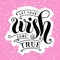 Lettering of Let your wish come true in black on pink background with white small stars