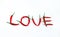 Lettering love written with chili peppers on white background,