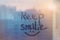 lettering text Keep smile and happy smile painted on window flooded with raindrops on blur blue glass background in city