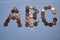 Letters a b c of copper coins insulated on a white sheet of paper.