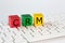 The letters CRM stand for Customer Relationship Management. These letters are written in black on red, green and yellow blocks and