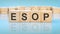 letters ESOP made with wood building blocks. blue background. business concept