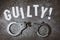 The letters with the inscription - guilty. Top view on social concept with handcuffs