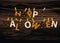 The letters and the inscription of a happy Halloween hang on clothespins on a rope or string. Vector on wooden background.