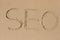 The letters S E O drawn in the sand