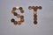 Letters s t of copper coins insulated on a white sheet of paper.