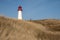 Leuchtturm List-West lighthouse in yellow field in List auf Sylt, Germany under blue sky