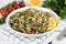 Levantine vegetarian Tabouleh salad with quinoa, tomatoes, cucumbers, parsley, lemon on white background. Macro.