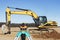 Level with an excavator in the background. Construction level or theodolite. Geodetic instruments and equipment for the