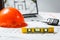 Level meter with blurred Orange hard hat, laptop  with drawings and walkie talkie on a background