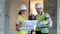 Leveling device and two construction specialists, builders, constructors standing near it and talking