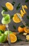 Levitating fresh sliced fruit, apple and orange with fork and knife isolated on wooden background