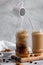 Levitating jar pouring almond milk over iced coffee