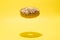 Levitating yellow donut on a yellow background