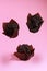 levitation of chocolate chip muffins isolated on pink background