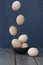 Levitation of eggs above ceramic bowl with eggs on dark blue background