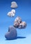 Levitation. Falling stones in the shape of a heart on a blue background.