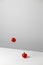 Levitation of fresh cut tomato. Fresh cherry tomatoes fly in the air. Stylish trendy creative art composition on white table